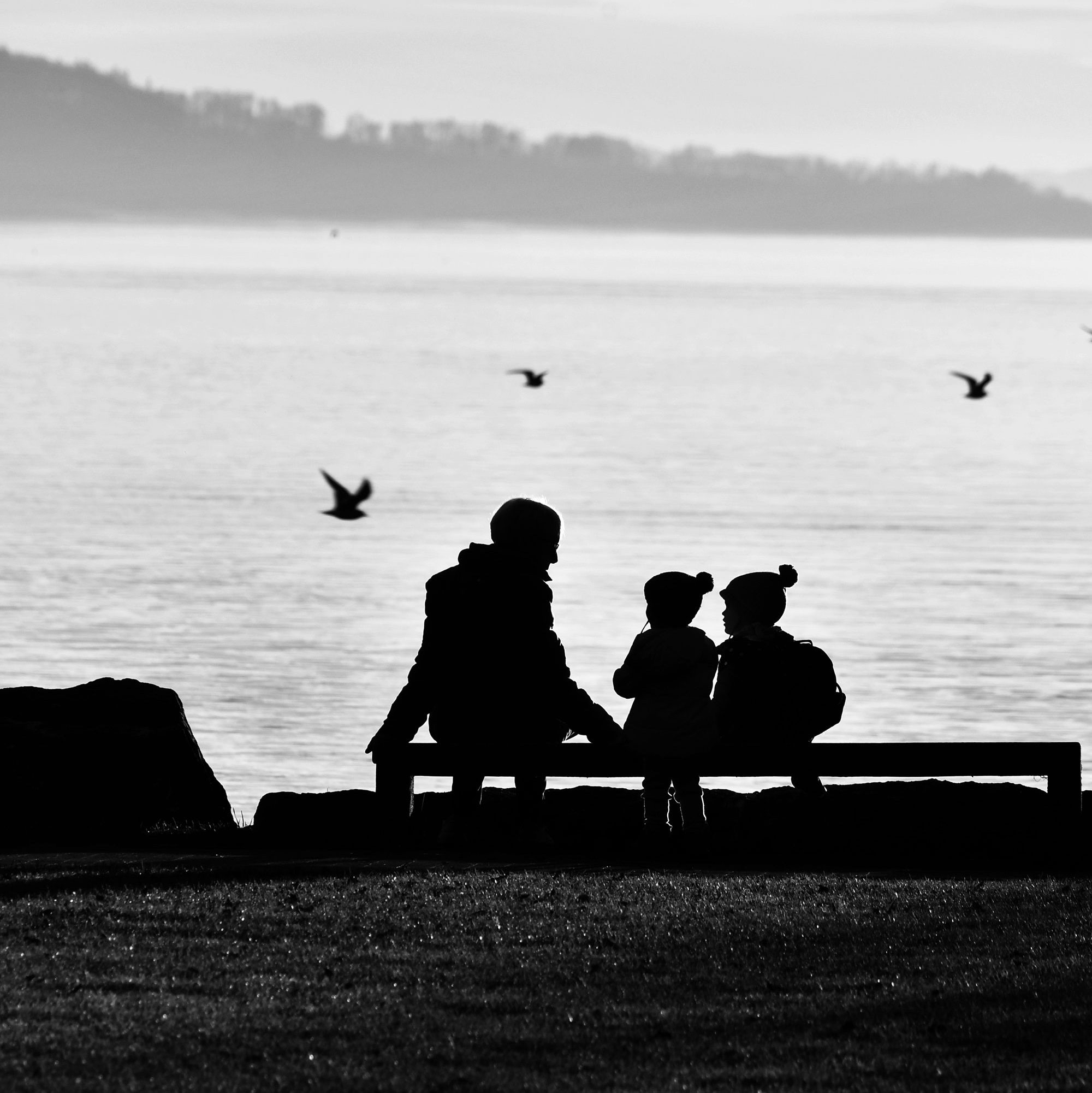 adult and children talking by the seaside